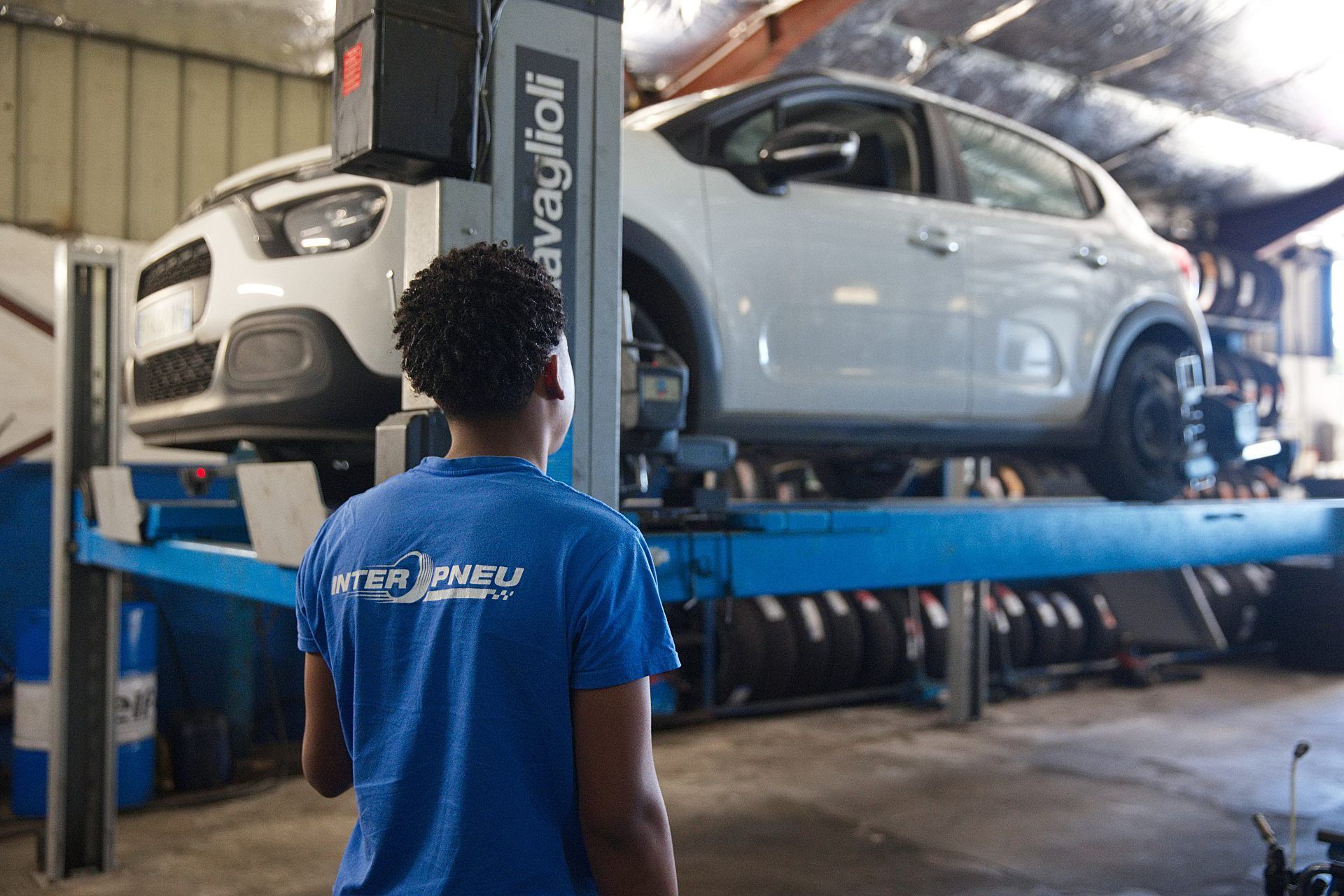 Technicien qui inspecte une voiture sur un pont élévateur