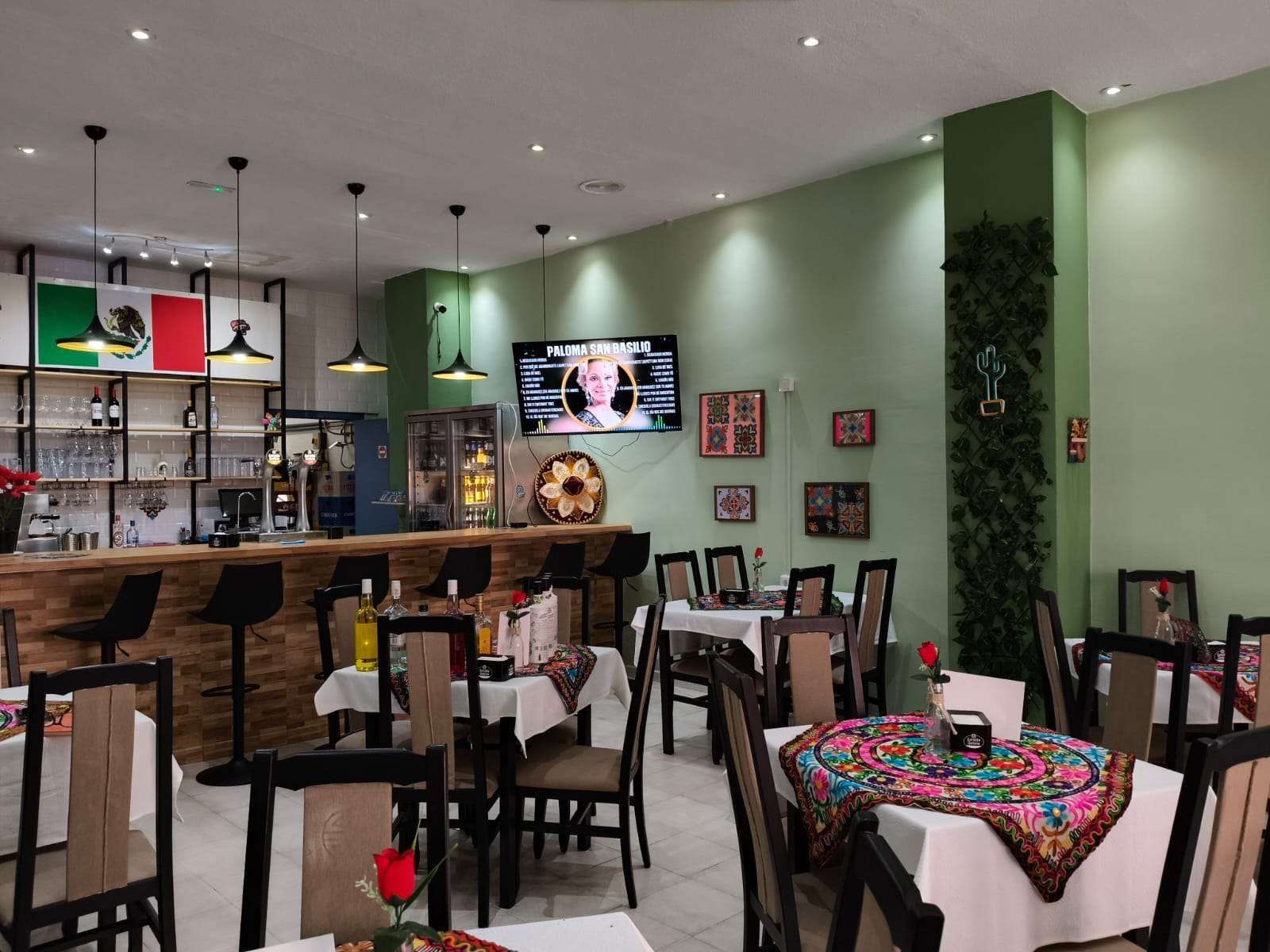 Un restaurante con mesas y sillas y un televisor en la pared.