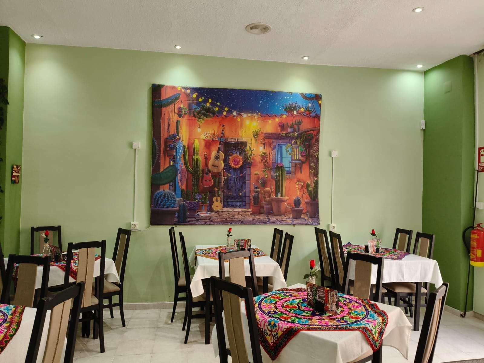 Un restaurante con mesas y sillas y un gran cuadro en la pared.