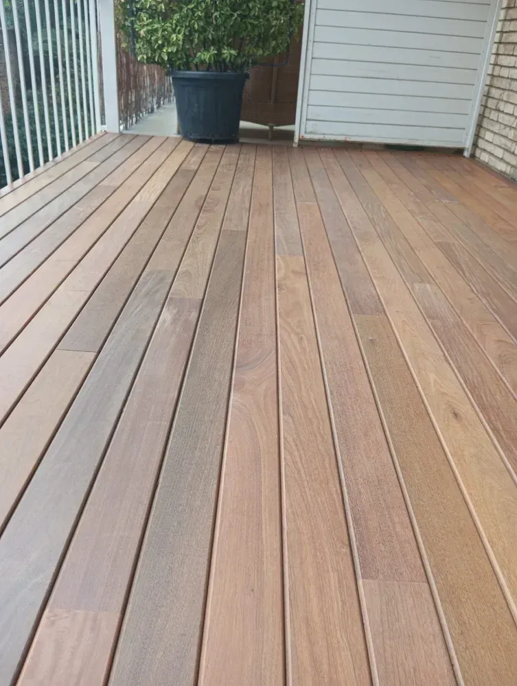 Una terraza de madera con una planta en maceta encima.