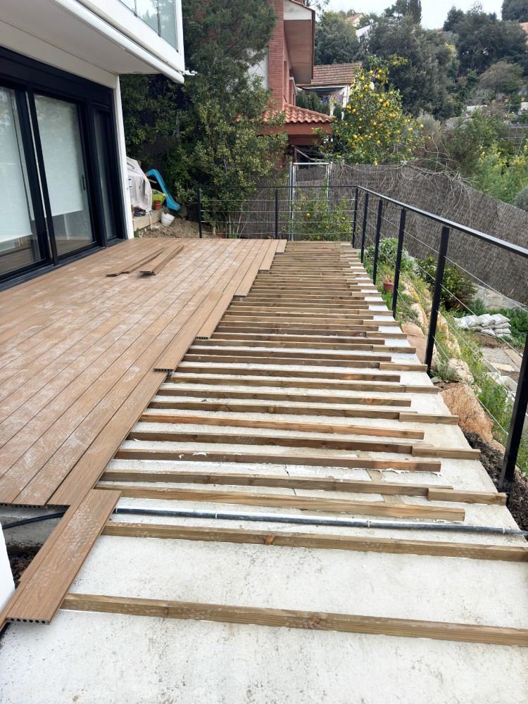 Se está construyendo una terraza de madera en el patio trasero de una casa.
