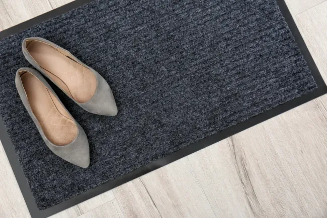 Un par de zapatos encima de un felpudo.