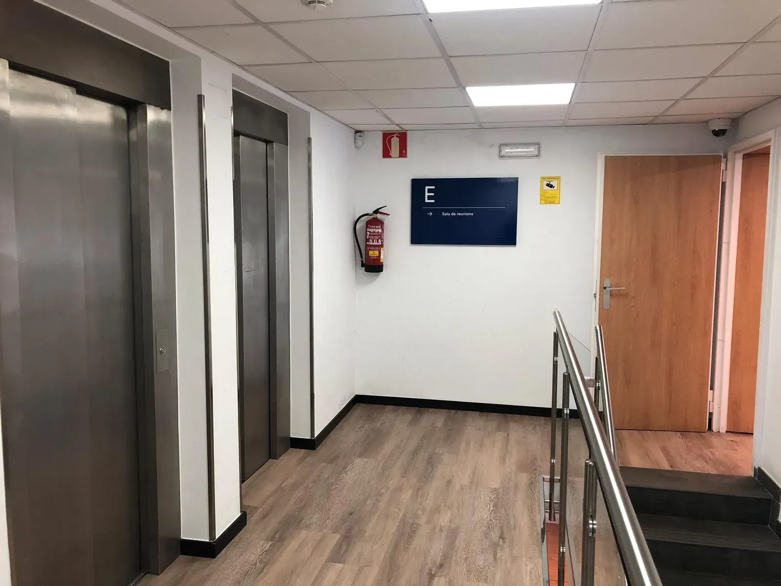 Un pasillo con ascensores y escaleras en un edificio.