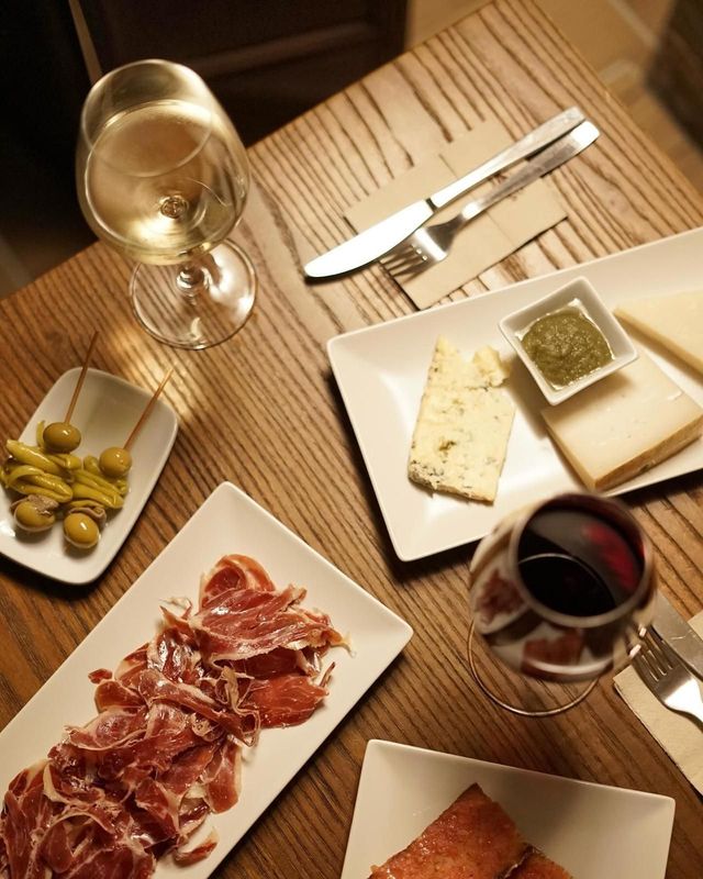 Una mesa cubierta con platos de comida y una copa de vino.