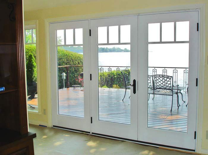 Una sala de estar con vista a un lago a través de las puertas corredizas de vidrio.