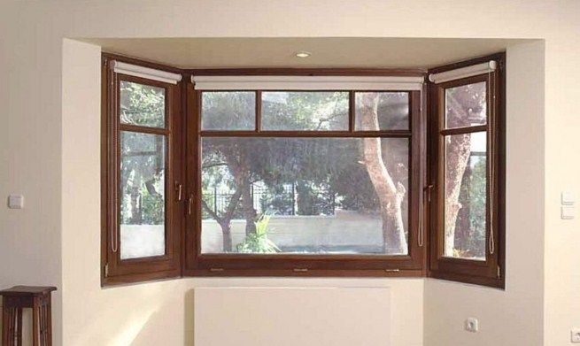 Una sala de estar con un gran ventanal con vista a los árboles.