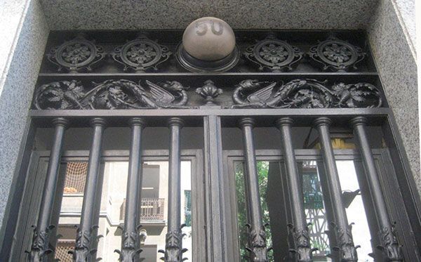 Una puerta de hierro forjado con una bola encima.
