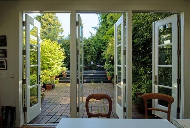Una habitación con una mesa y sillas abierta a un patio.