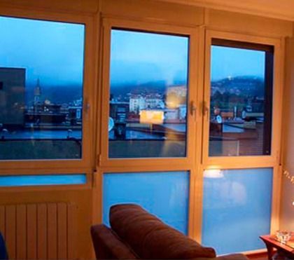 Una sala de estar con muchas ventanas y un sofá.