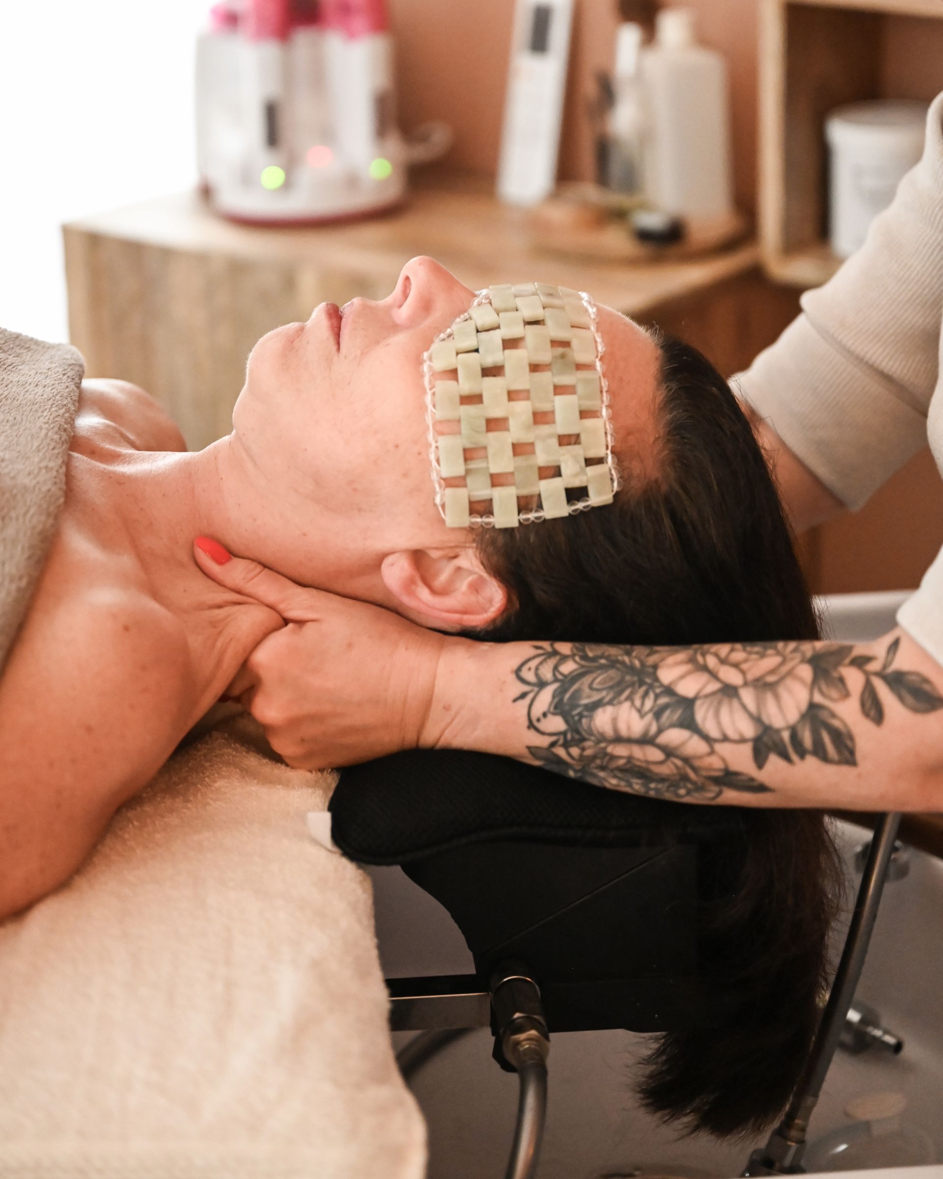 Un soin du visage dans une cabine de spa, avec un praticien travaillant sur un client allongé.