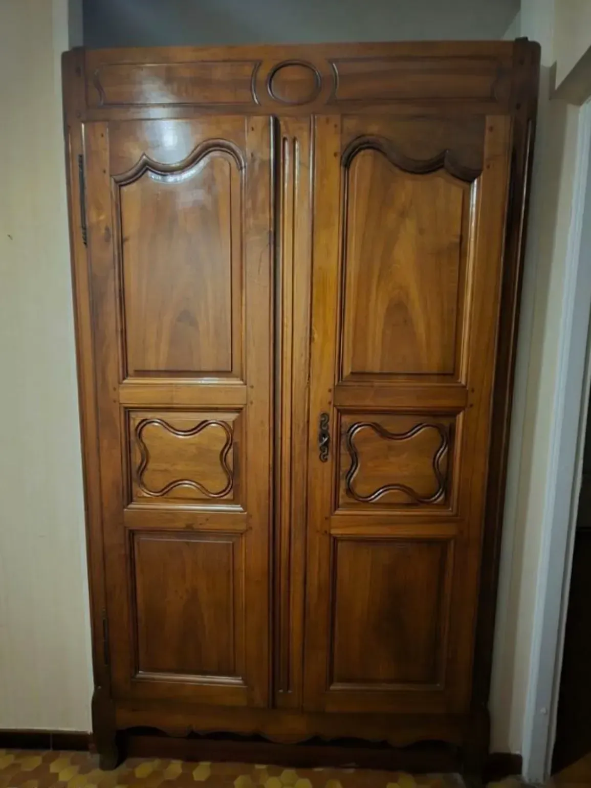 Armoire en bois à deux portes et sculptures décoratives.