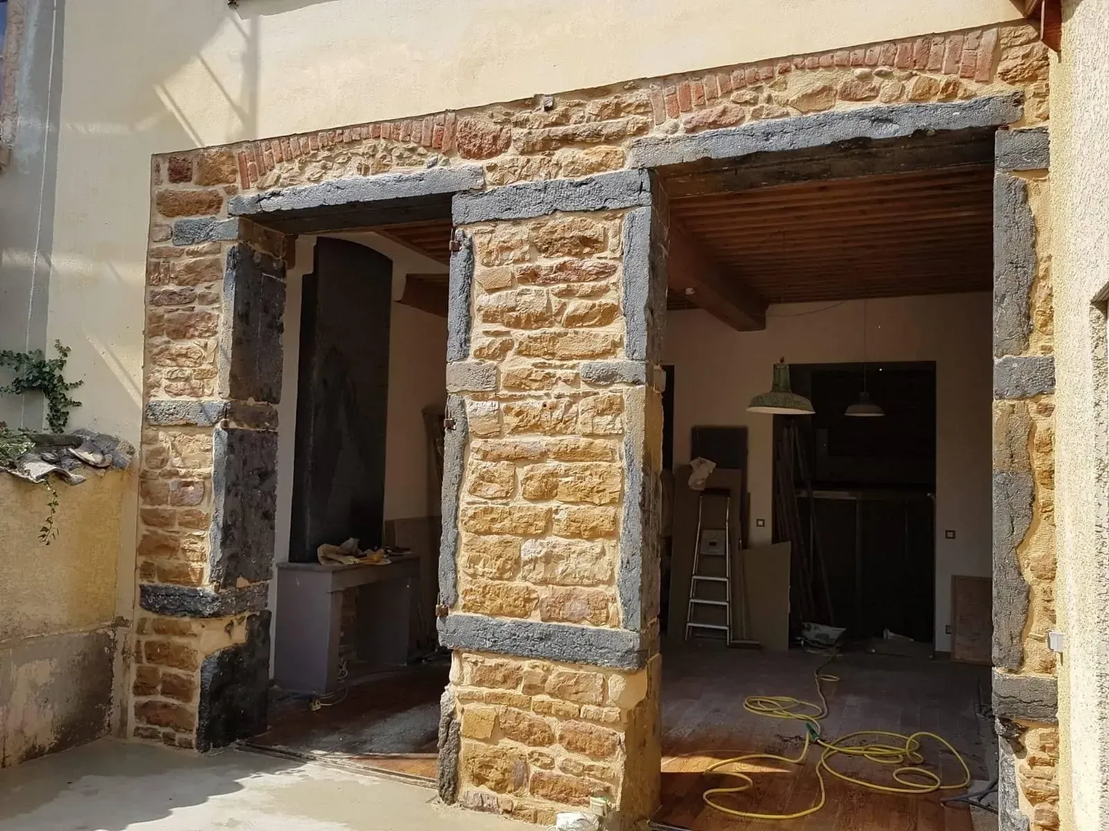 Porte extérieure en pierre avec moulures sombres.