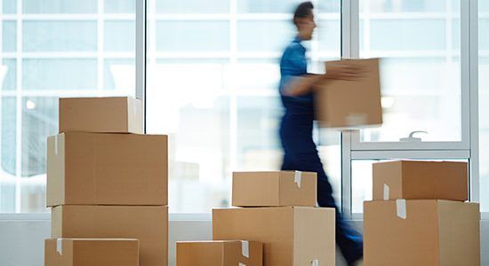 Représentation d'une pile de carton et d'un déménageur.