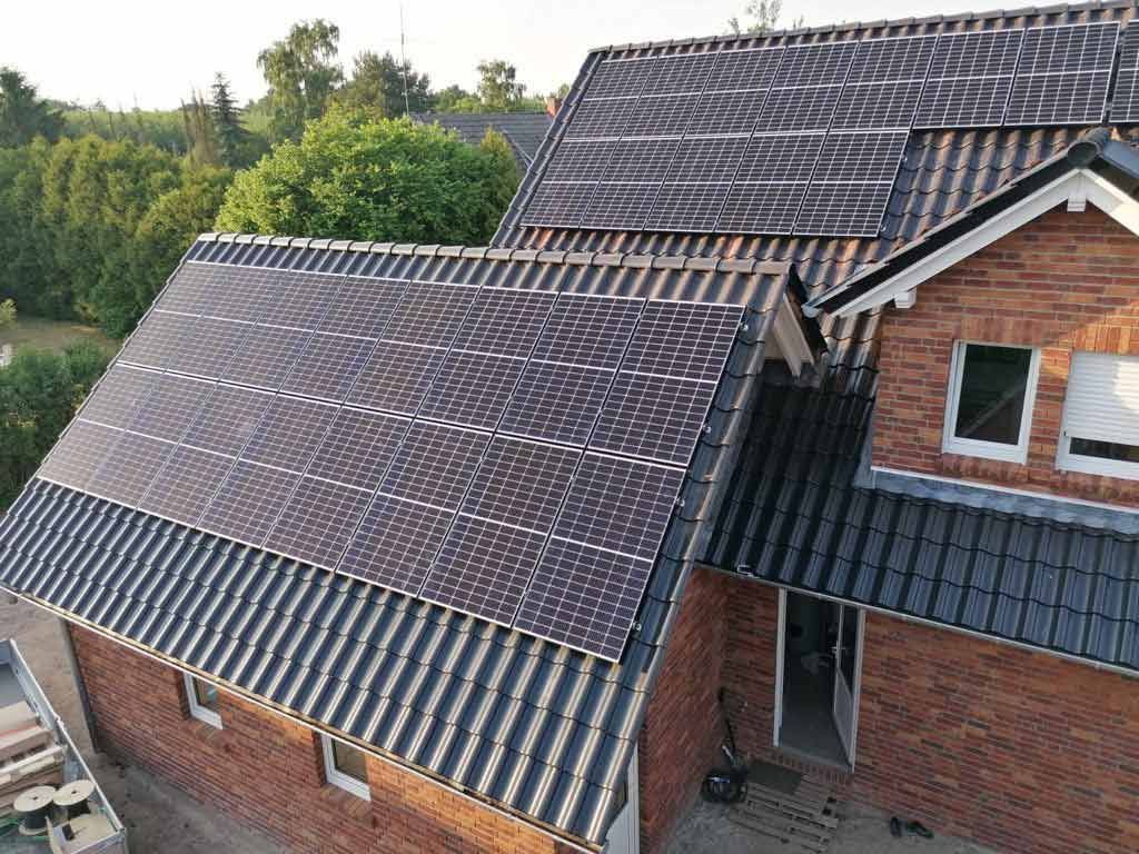 Ein Backsteinhaus mit Sonnenkollektoren auf dem Dach.