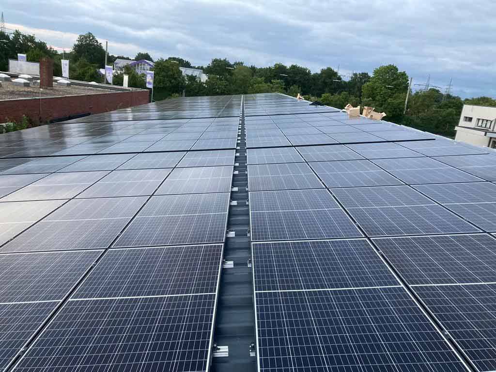 Auf dem Dach eines Gebäudes befinden sich viele Solarmodule.