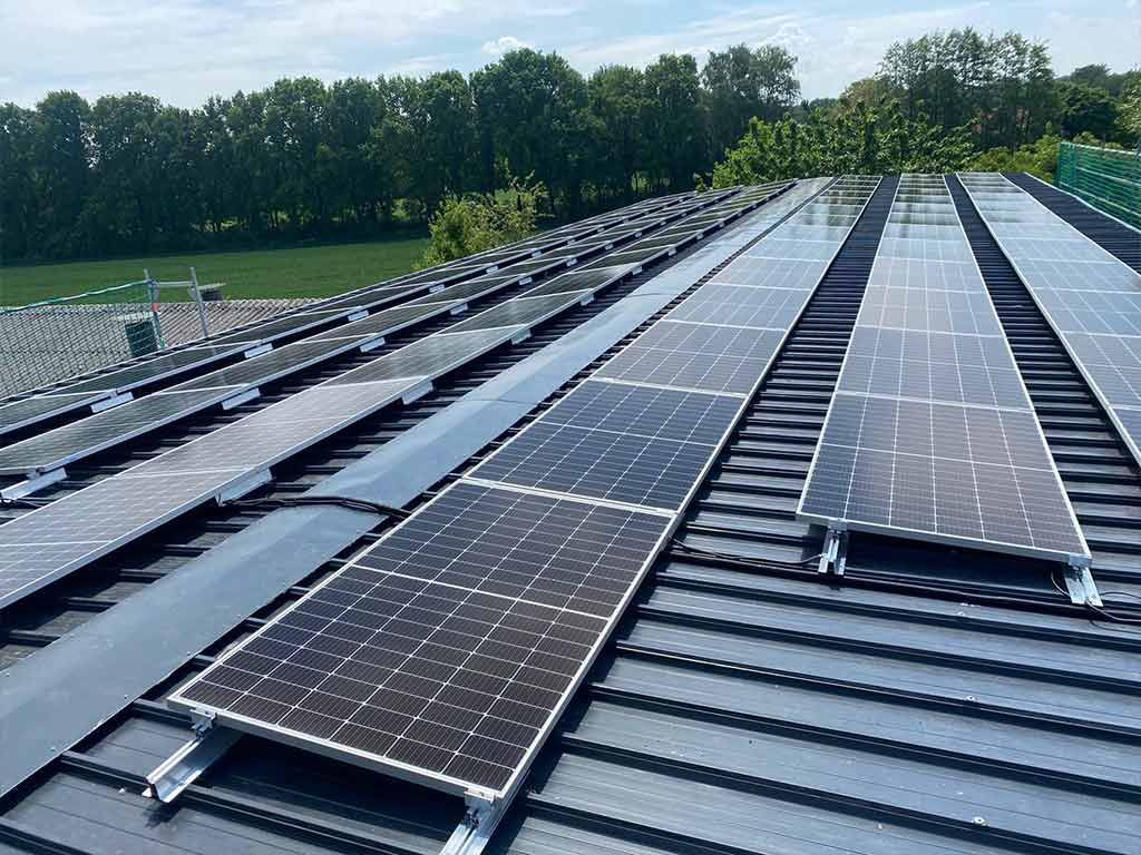 Auf dem Dach eines Gebäudes befinden sich viele Solarmodule.