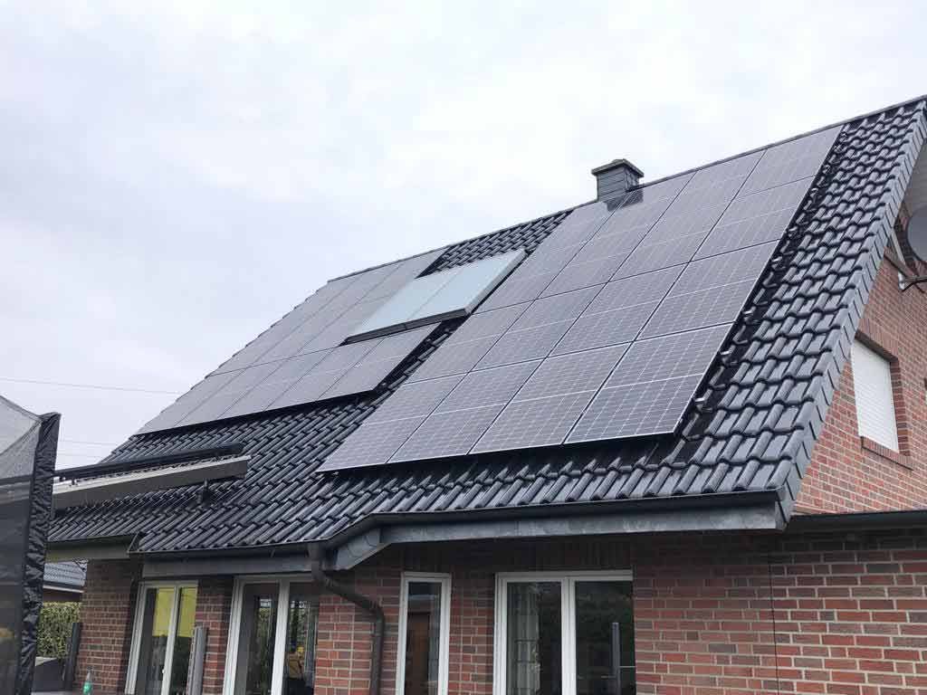 Ein Backsteinhaus mit Sonnenkollektoren auf dem Dach.