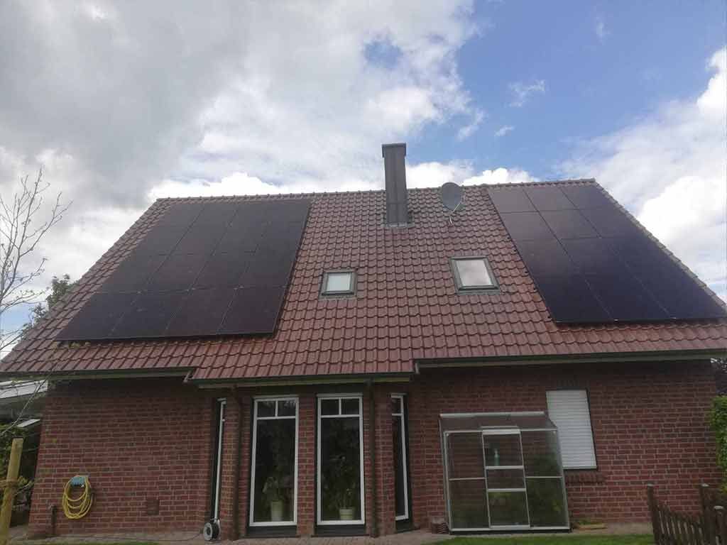 Ein Backsteinhaus mit Sonnenkollektoren auf dem Dach.