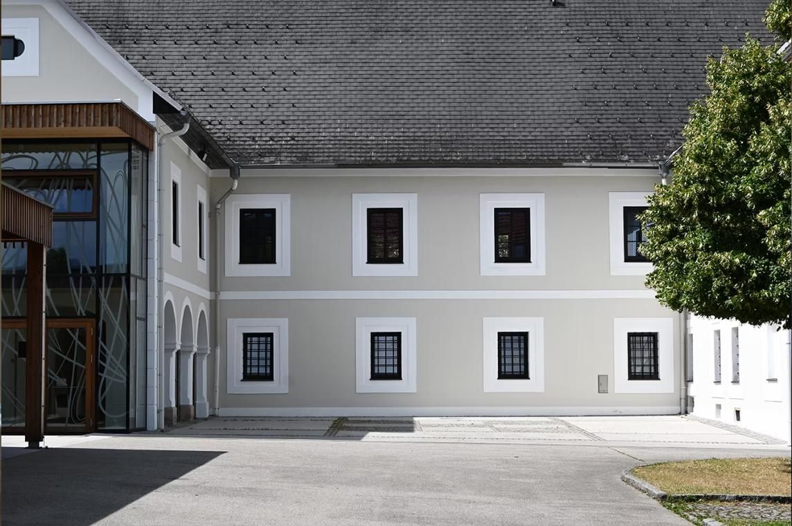 Ein großes Gebäude mit einem Baum davor