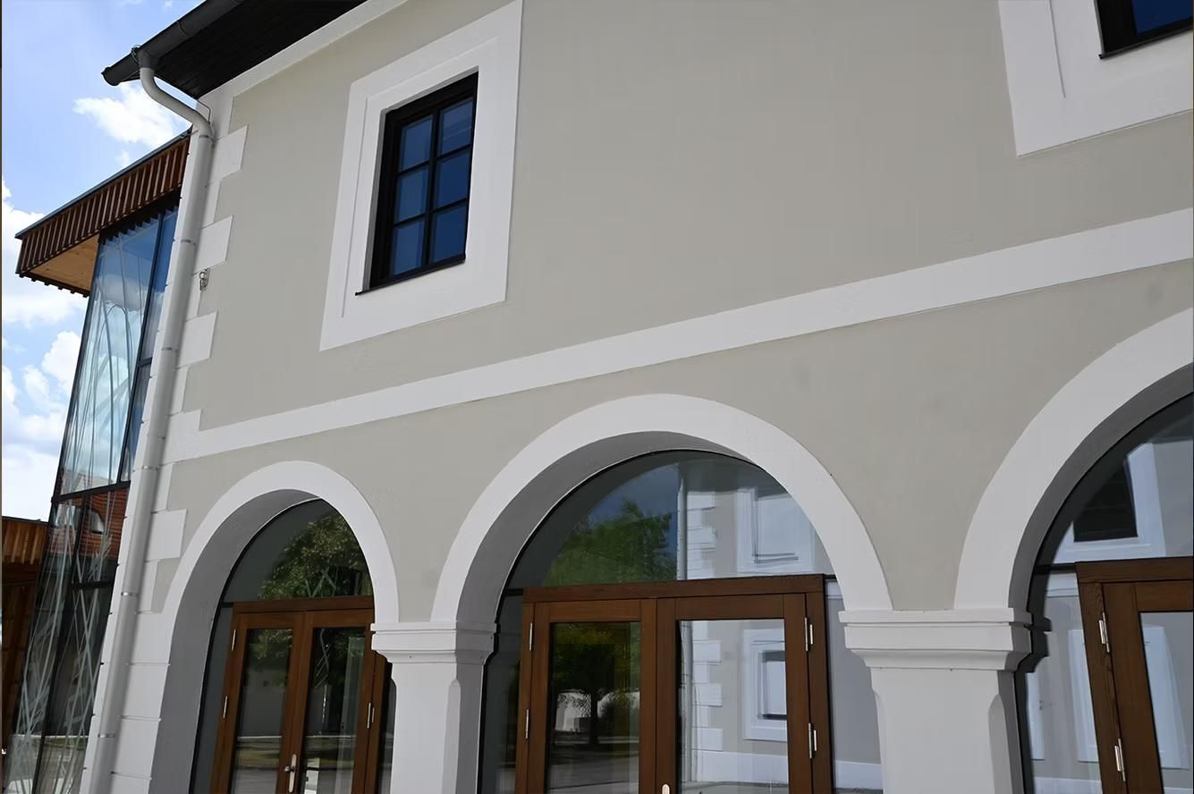 Die Vorderseite eines Gebäudes mit Bögen und Fenstern