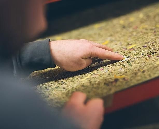 Eine Person berührt mit ihrem Finger ein Stück Schaumstoff.