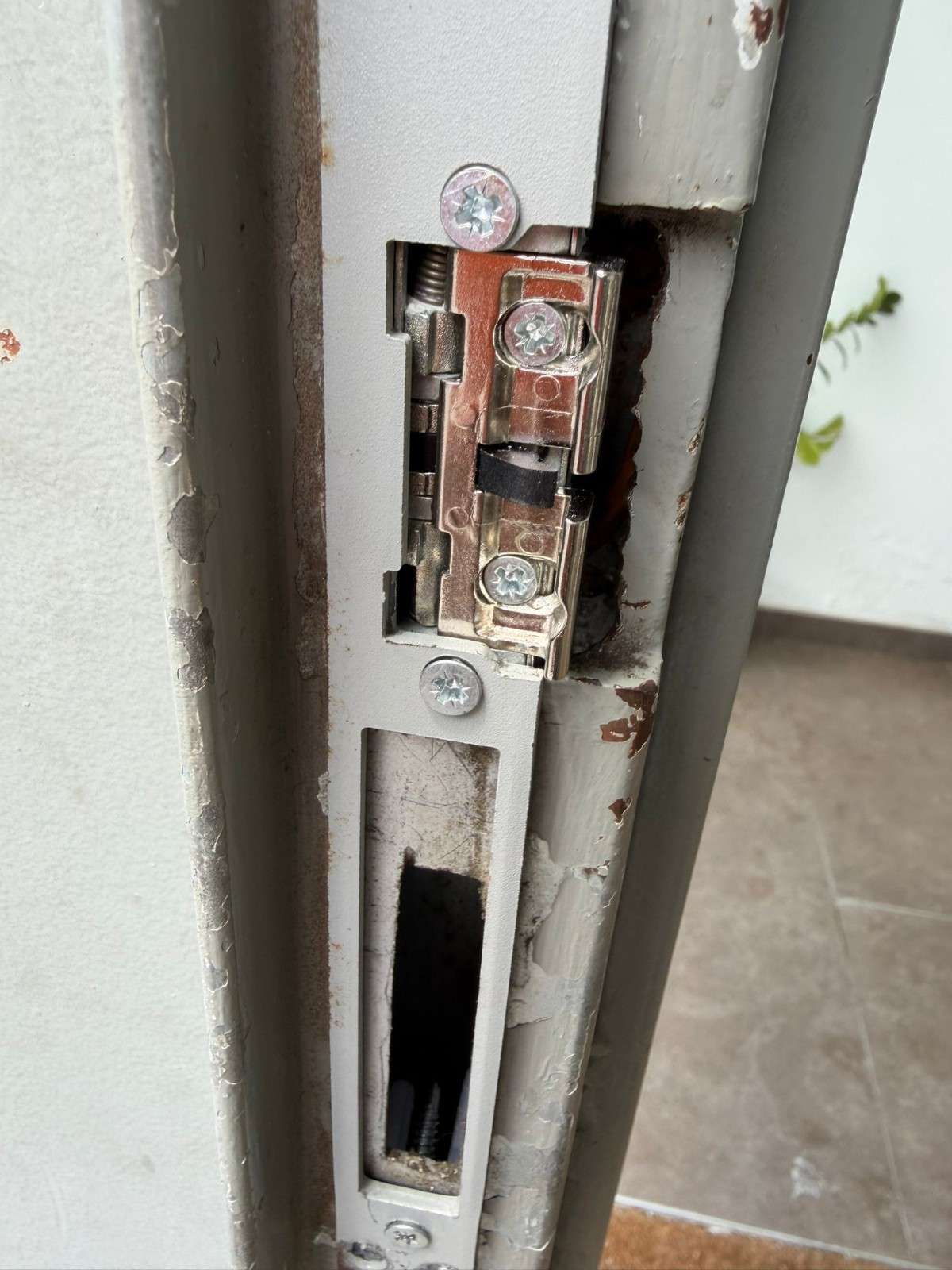Dos cilindros de cerradura metálicos, uno de latón y otro de plata, con llaves insertadas en una superficie moteada.