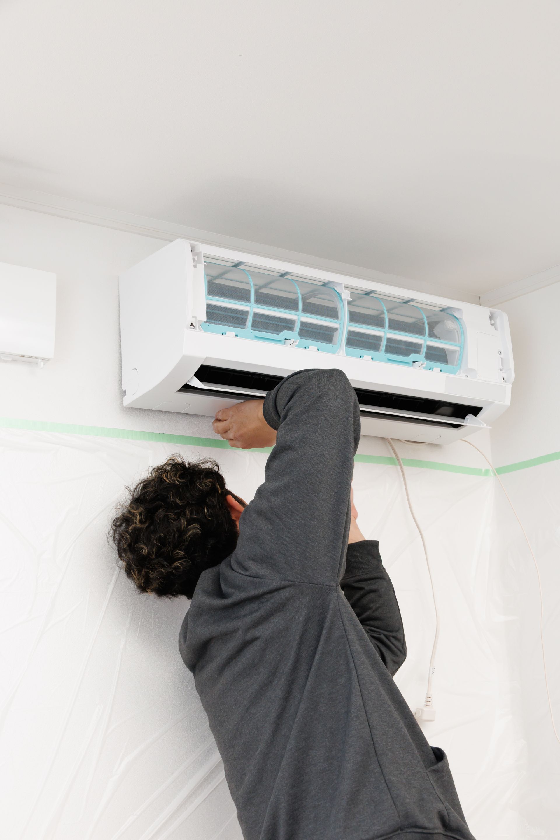 Un technicien entretient la climatisation murale