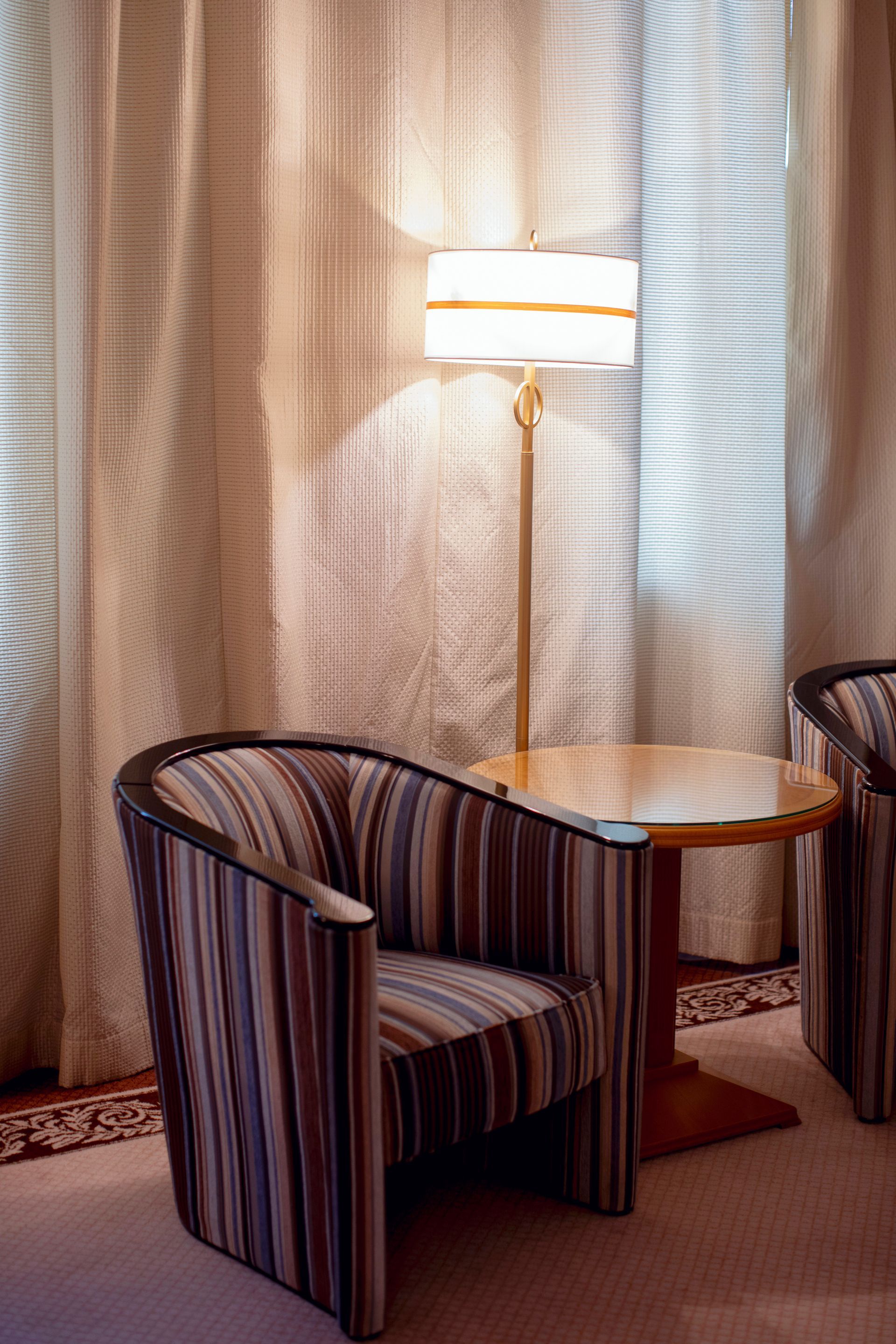 Un lampadaire entre des fauteuils et derrière une table basse