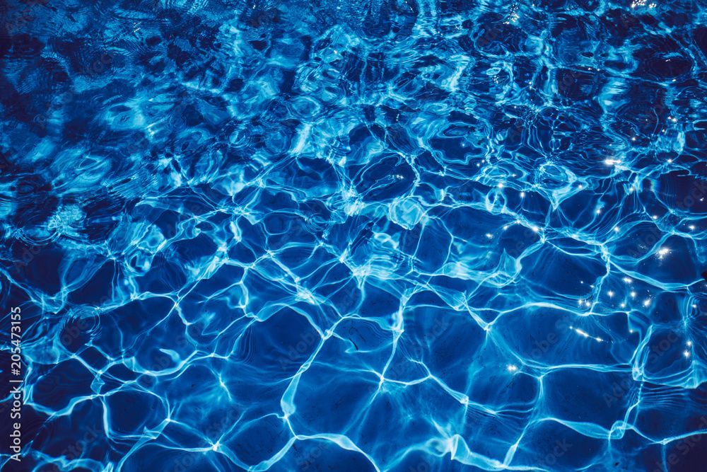 Blaue Wasseroberfläche mit Lichtreflexionen.