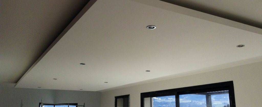Plafond moderne avec des spots encastrés et une fenêtre à cadre noir en dessous