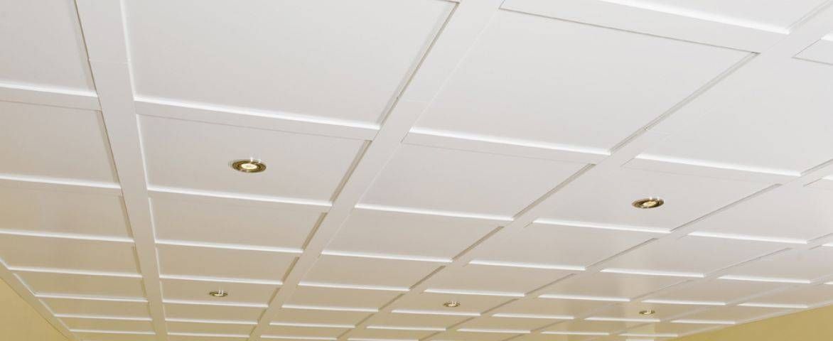 Plafond blanc carrelé avec des spots encastrés dans une pièce