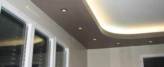 Plafond moderne avec des spots encastrés et un éclairage indirect courbe au-dessus des fenêtres