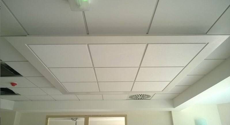 Plafond blanc de bureau avec des panneaux encastrés, des bouches d’aération 