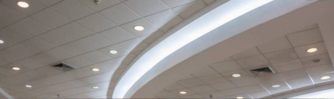 Plafond blanc incurvé avec des spots encastrés dans un espace intérieur moderne