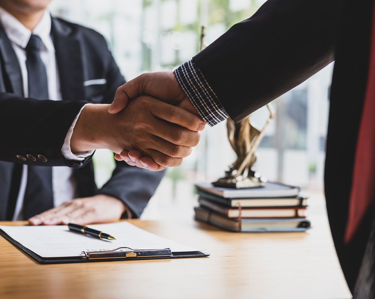 Avocat à son bureau qui serre la main de son client