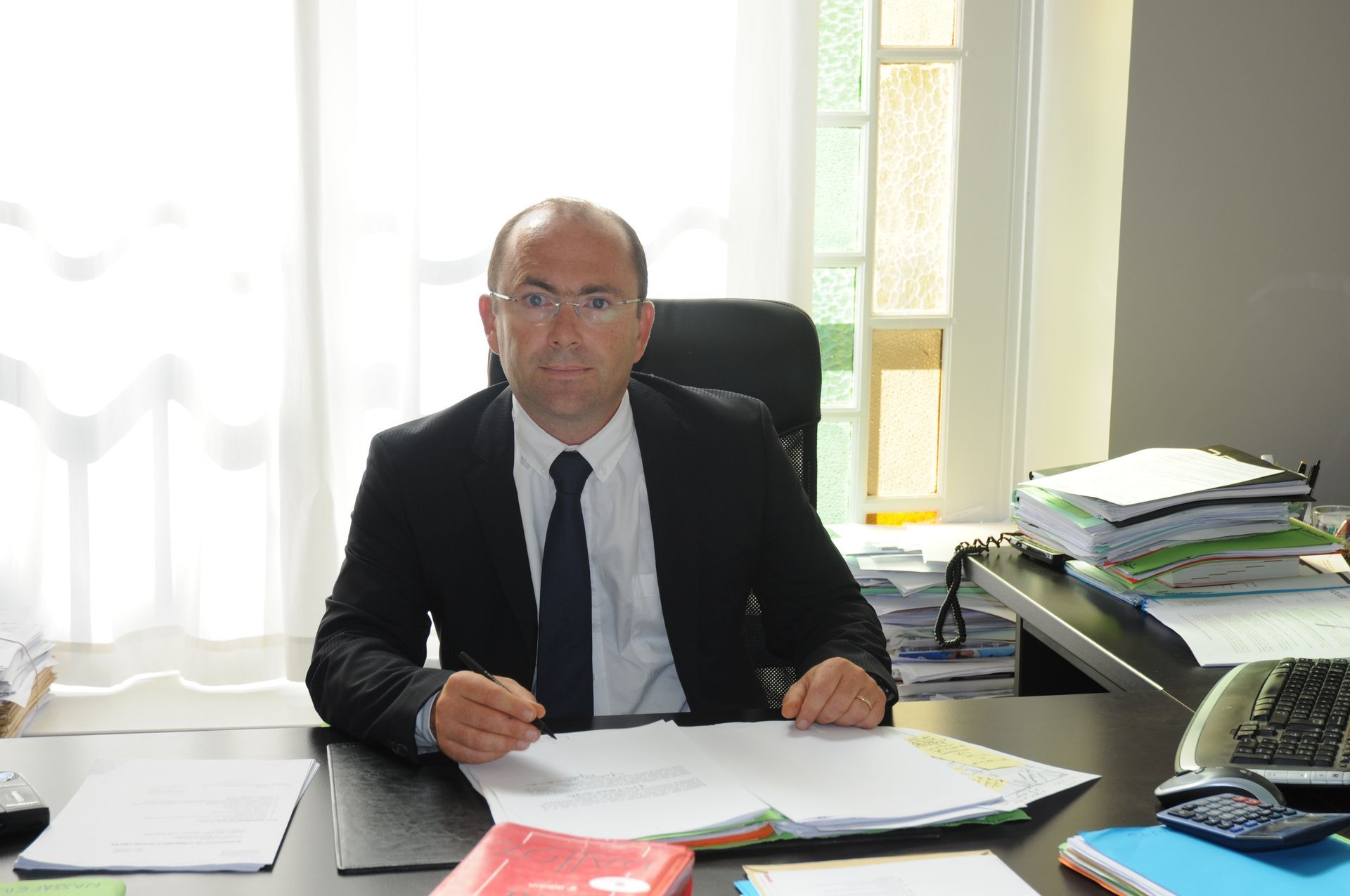 Maître Xavier CLAUDE à son bureau en train de signer des documents