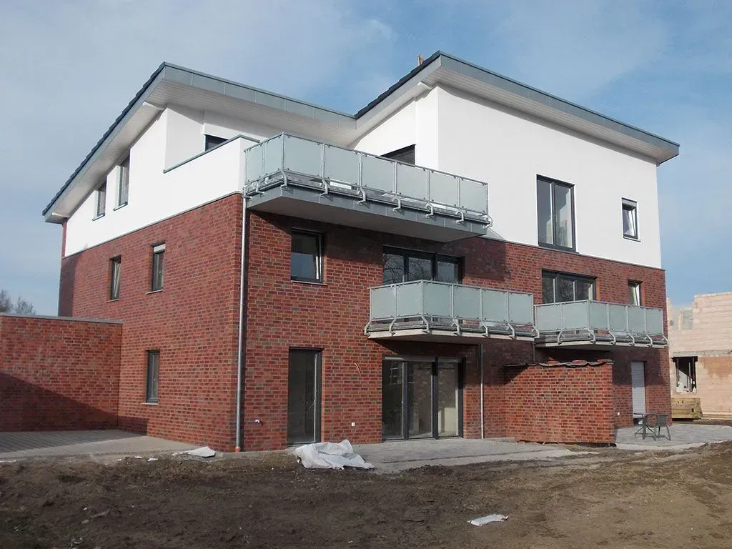 ein rot-weißes Backsteingebäude mit zwei Balkonen