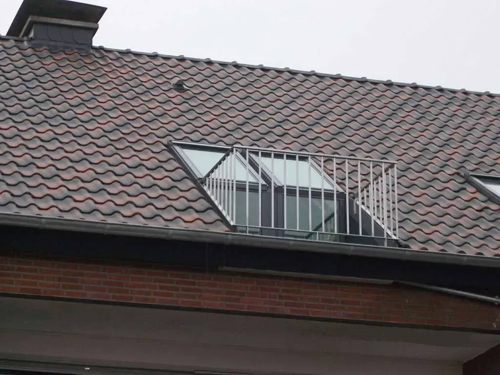 das Dach eines Gebäudes mit einem Balkon darauf