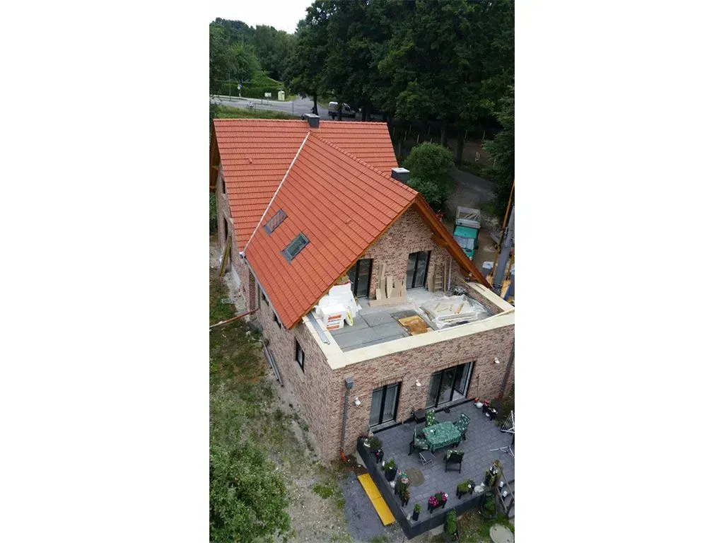 eine Luftaufnahme eines Hauses mit einem roten Dach