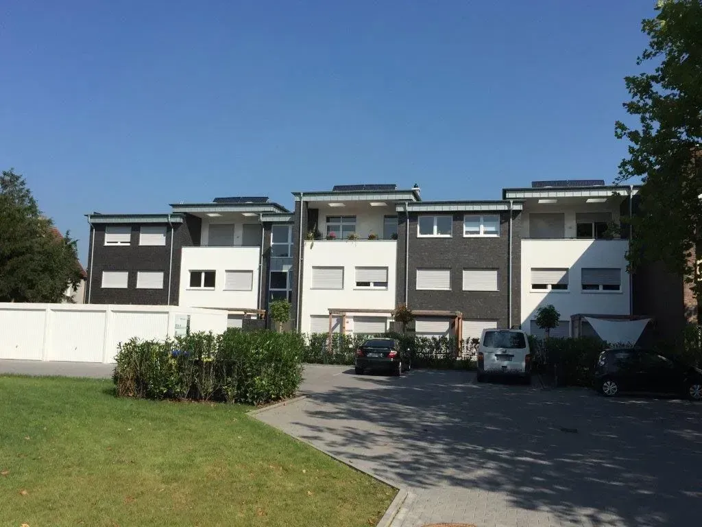 ein Reihenhaus mit grüner Wiese