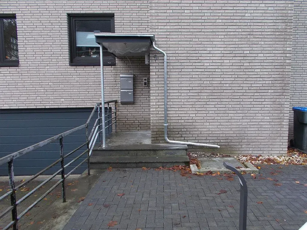 ein Backsteingebäude mit einer Garage und einer Treppe