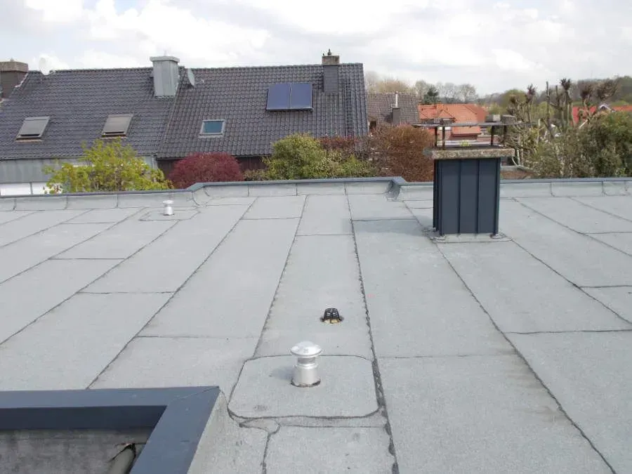 das Dach eines Hauses mit einem Schornstein darauf