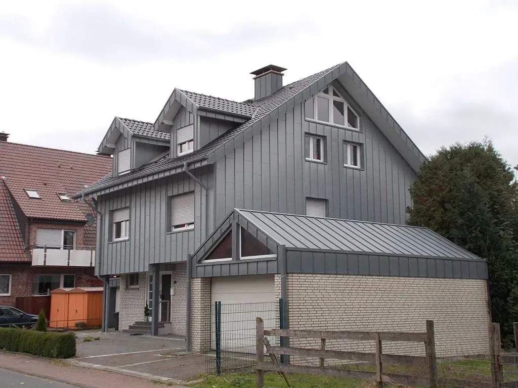 ein graues Haus mit einer Garage davor