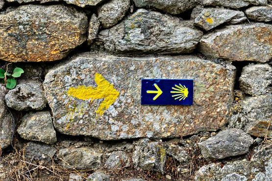 señal al Camino de Santiago en pared de piedra