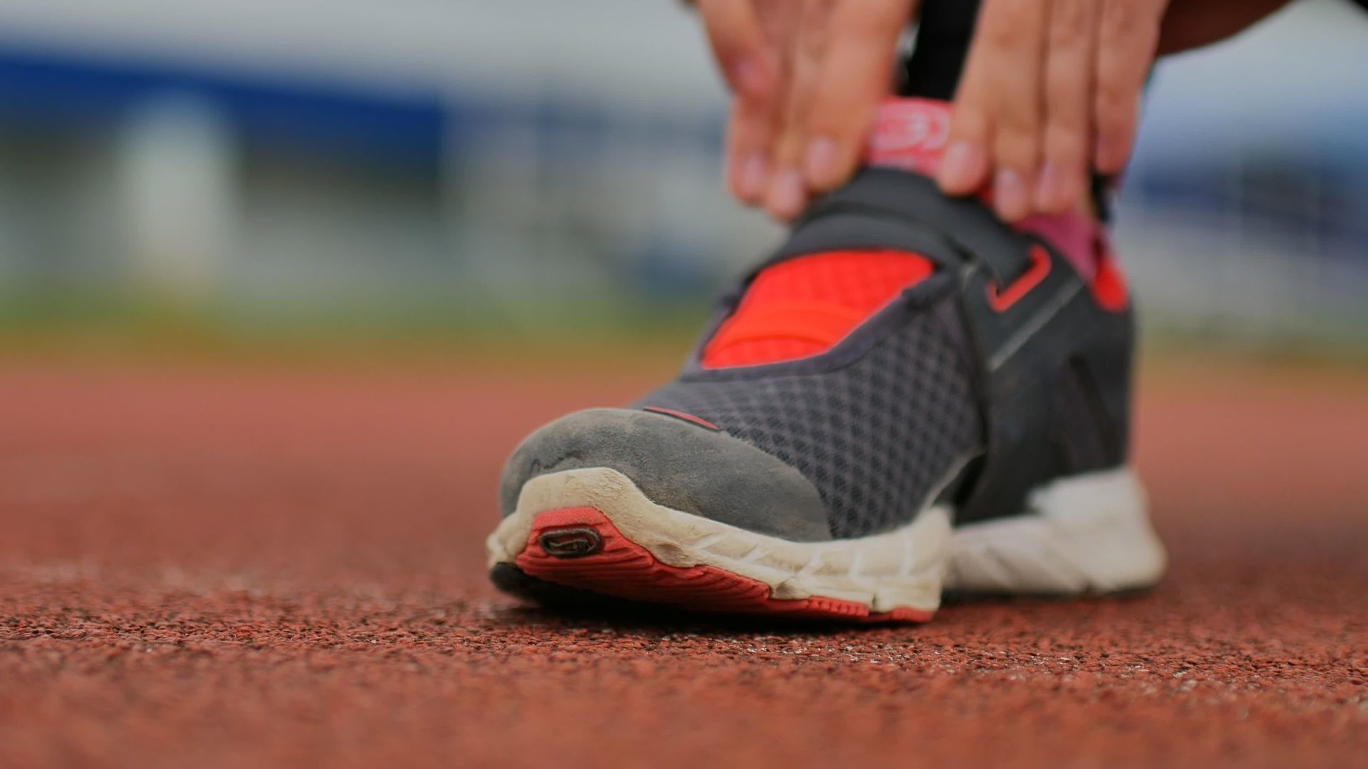 Una persona se ata las zapatillas para correr en una pista.