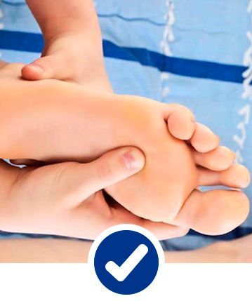 Una persona está dando un masaje de pies con una marca de verificación en la esquina.