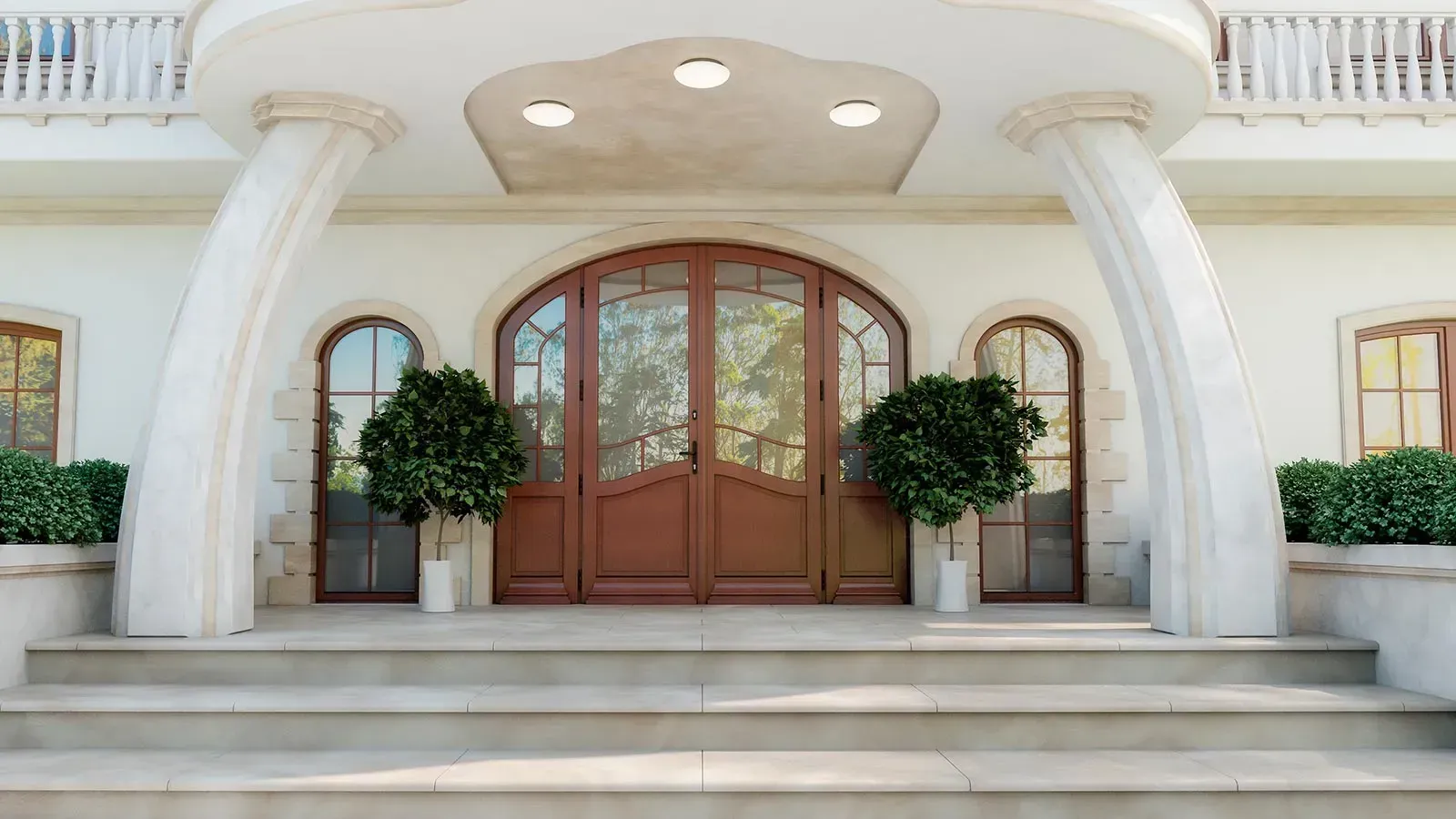 Weißer Herrenhauseingang mit großen braunen Türen, Säulen und Stufen. Zwei kleine Bäume flankieren die Tür.