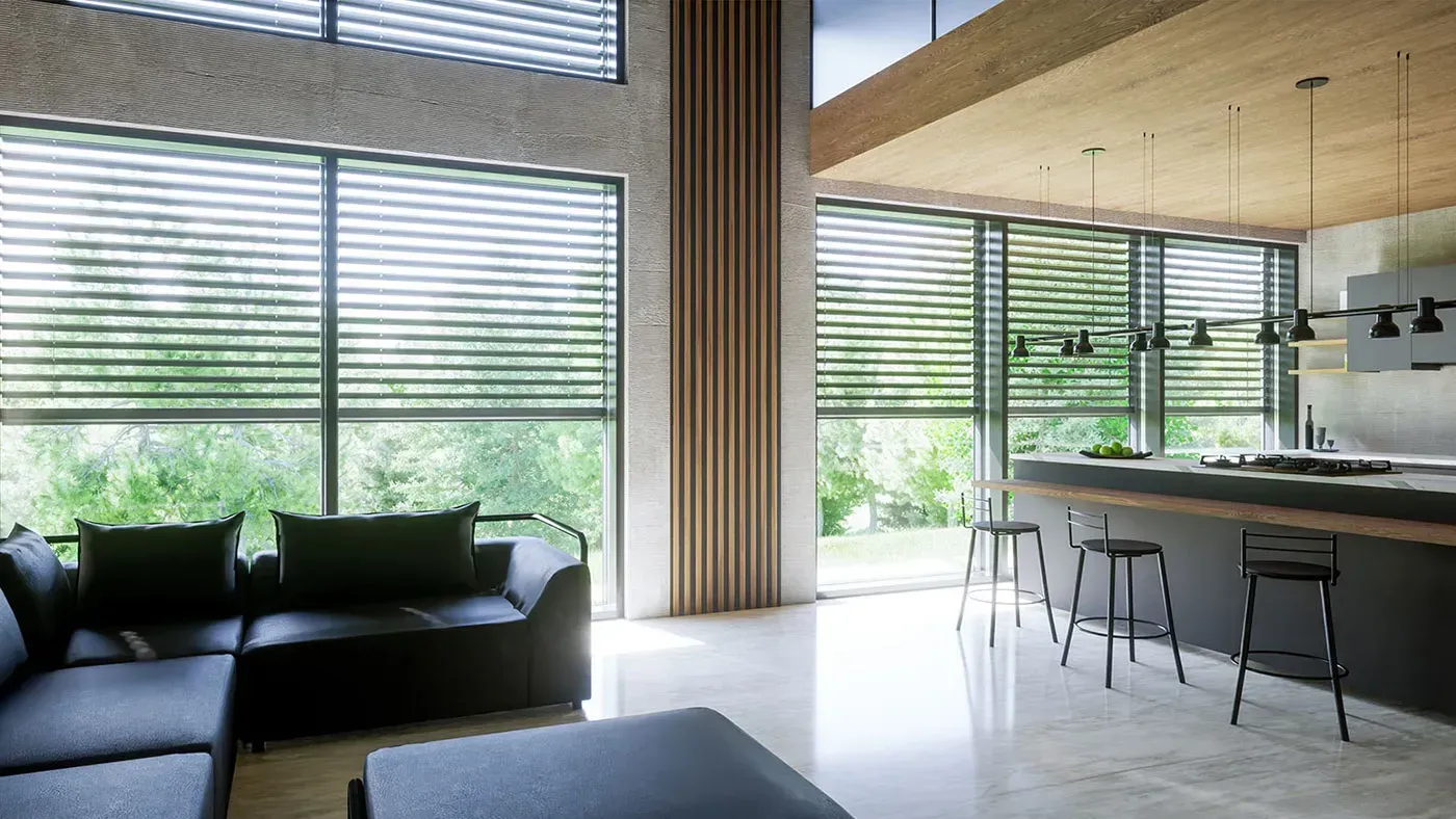 Modernes Wohnzimmer mit schwarzem Sofa, Küchenbar und großen Fenstern mit Blick ins Grüne.