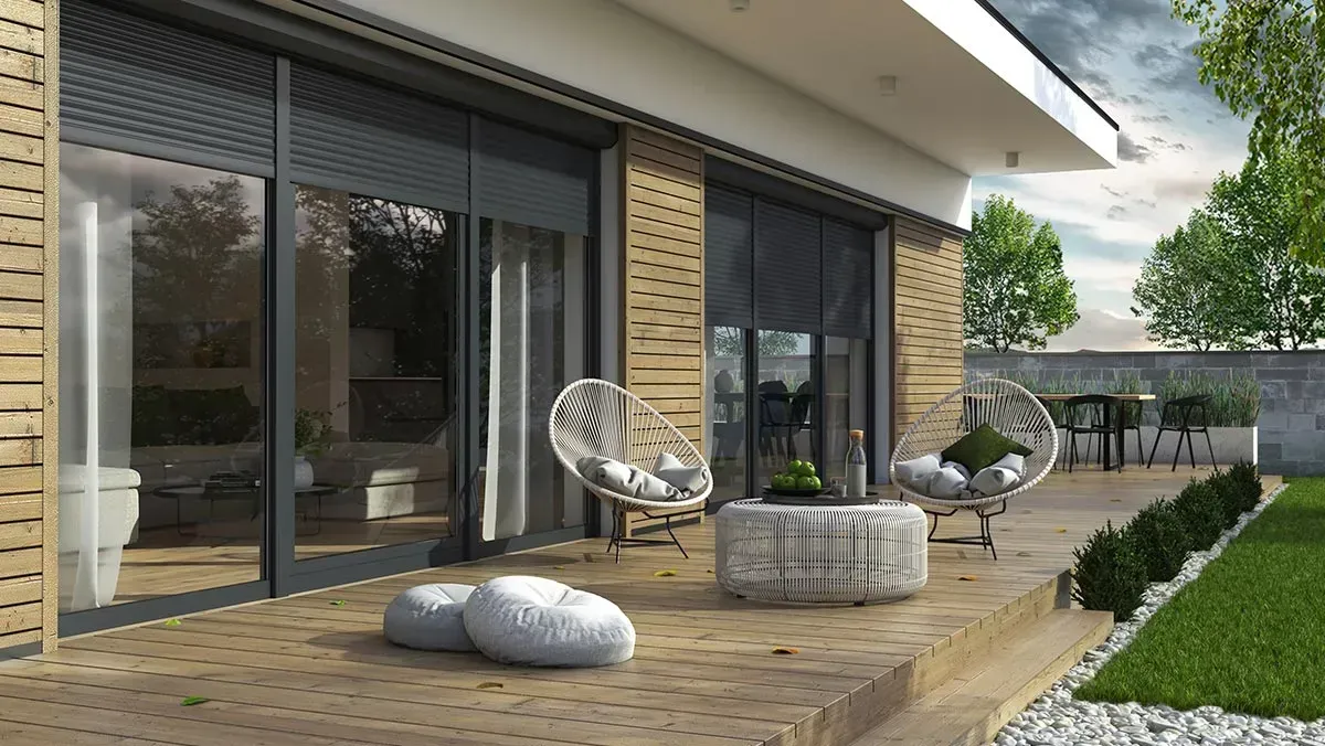 Terrasse mit modernen Möbeln, großen Fenstern mit Jalousien und einem Rasenhof.