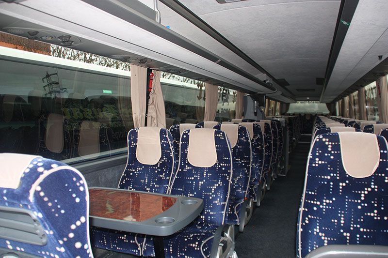 Das Innere eines Busses mit blauen Sitzen und einem Tisch